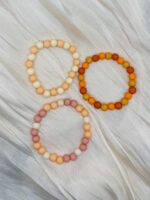 Handgefertigtes elastisches Perlenarmband in drei Naturfarben