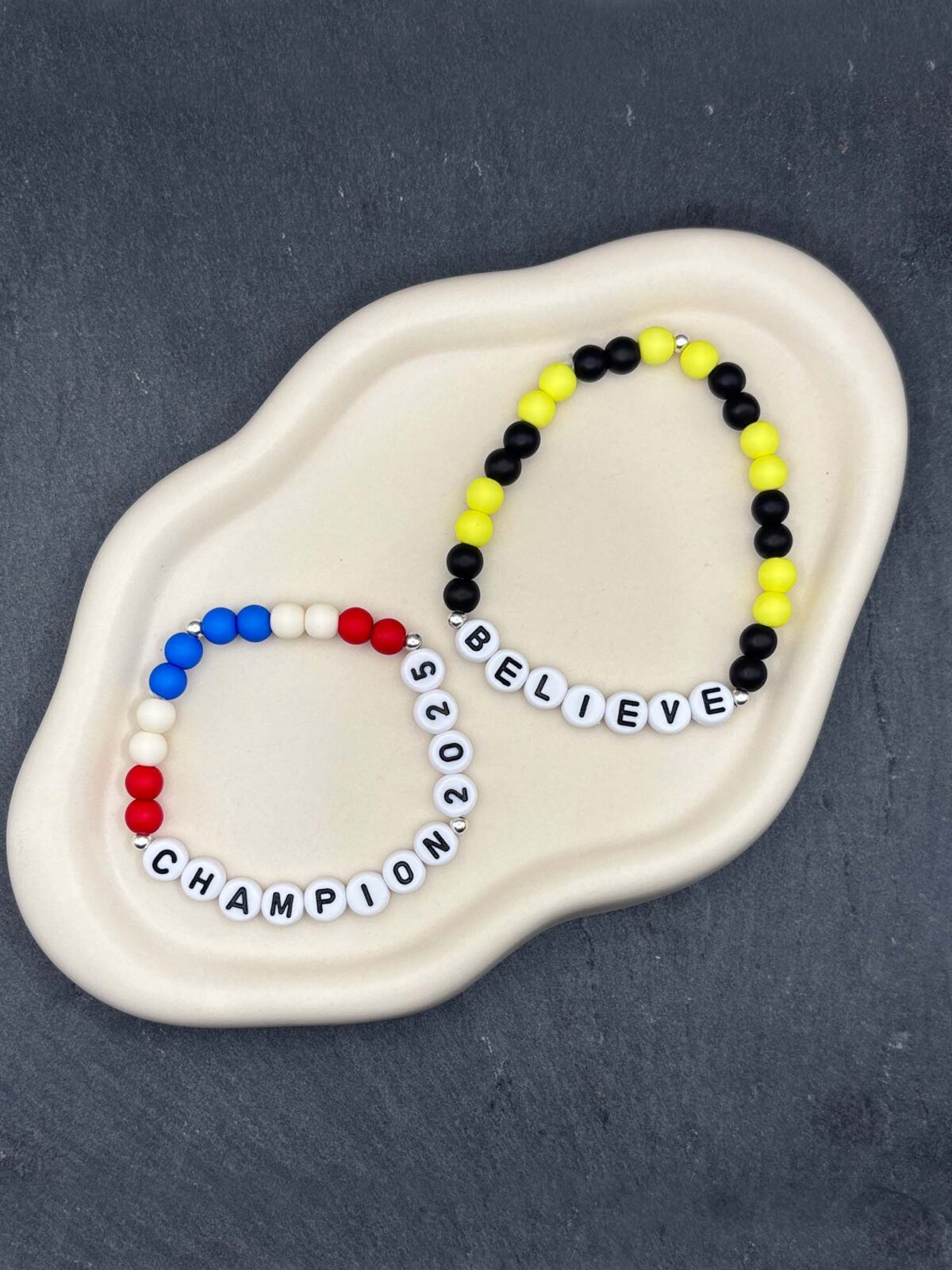 Bunte Fanarmbänder aus Perlen mit Schriftzug in Vereinsfarben