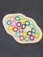 Bunte Perlenringe aus Glasperlen auf elastischem Faden