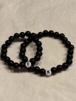 Handgemachtes Partnerarmband in Schwarz mit personalisierbaren Initialen als Symbol für Liebe und Zusammenhalt.