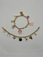 Zwei goldene Charm Armbänder mit Katze, Teddy, Herz, Schleife – liebevoll gestalteter Schmuck