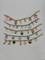 Mehrere Charmarmbänder in Gold und Silber – mit vielfältigen Charms wie Katzen, Herzen, LOVE, Schleife, Muscheln