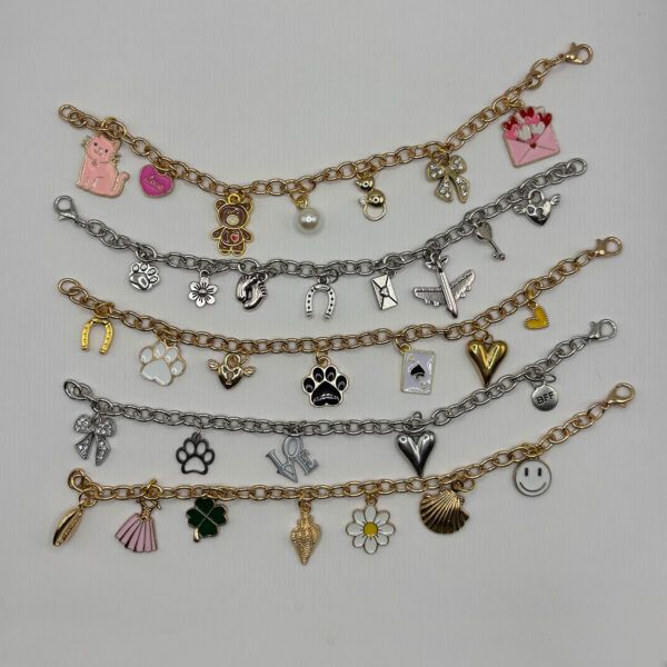 Mehrere Charmarmbänder in Gold und Silber – mit vielfältigen Charms wie Katzen, Herzen, LOVE, Schleife, Muscheln
