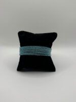 Elastisches Strassarmband in Türkis und Silber – glitzerndes Damenarmband mit Glassteinen, stretchfähig, auf schwarzem Samtkissen fotografiert.