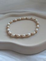 Detailaufnahme des Armbands mit unregelmäßigen Süßwasserperlen und kleinen goldfarbenen Perlen