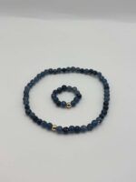 Two beaded bracelets in dark blue tones, each featuring a single gold spacer bead; shown on a pale background.